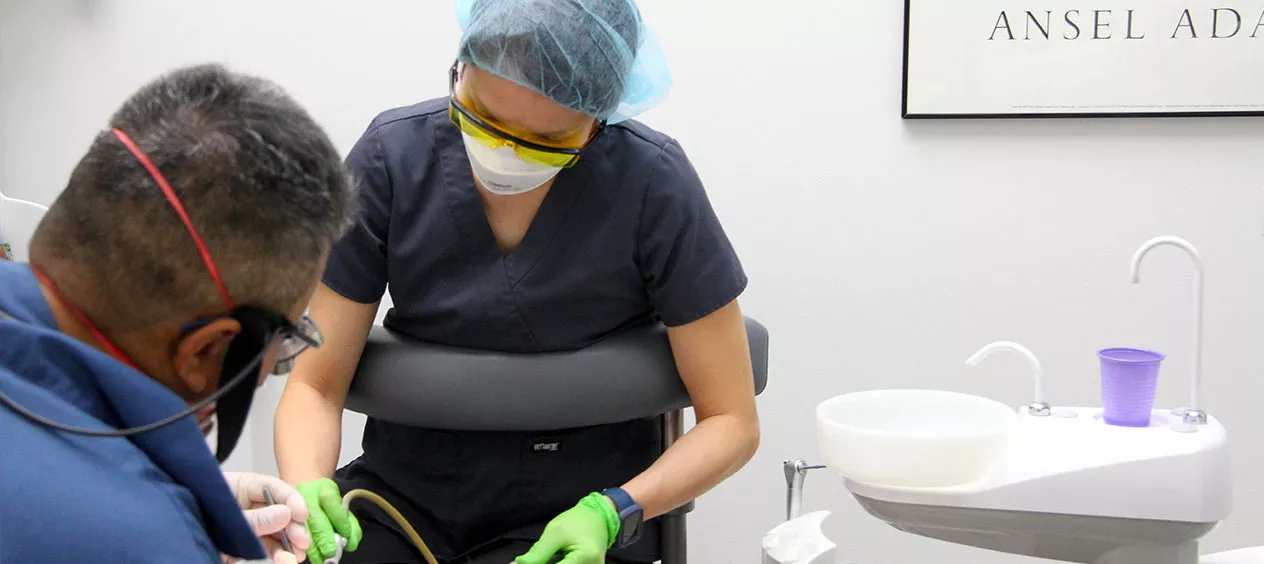 Dentist and hygienist performing dental procedure